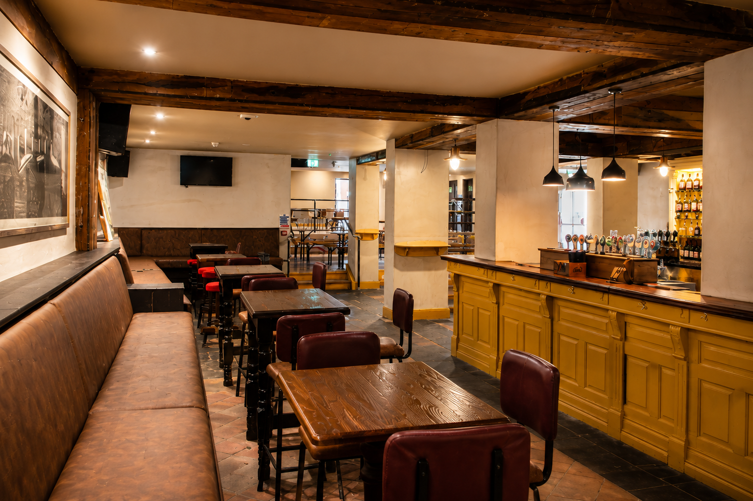 The yellow bar counter and booth seating in the dance hall