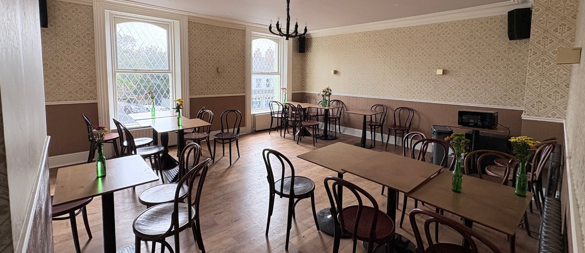 One of the Gold Room's rooms, with café tables and a chandelier