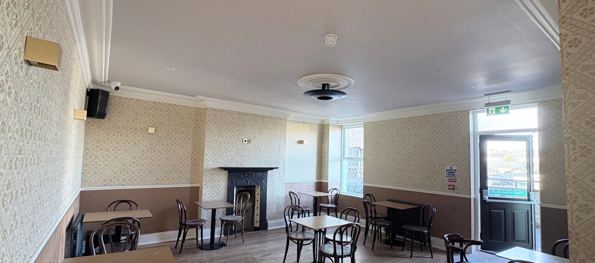 A Gold Room with an original fireplace and café seating